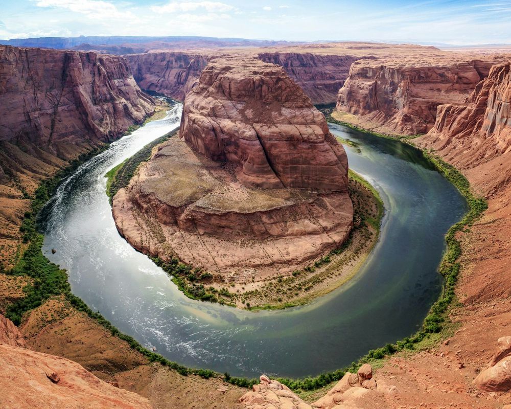 The Colorado River curving in a deep horseshoe loop through red sandstone cliffs at Horseshoe Bend