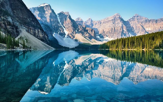 Snowy peaks of the Valley of the Ten Peaks reflected in the turquoise water of Moraine Lake in Banff