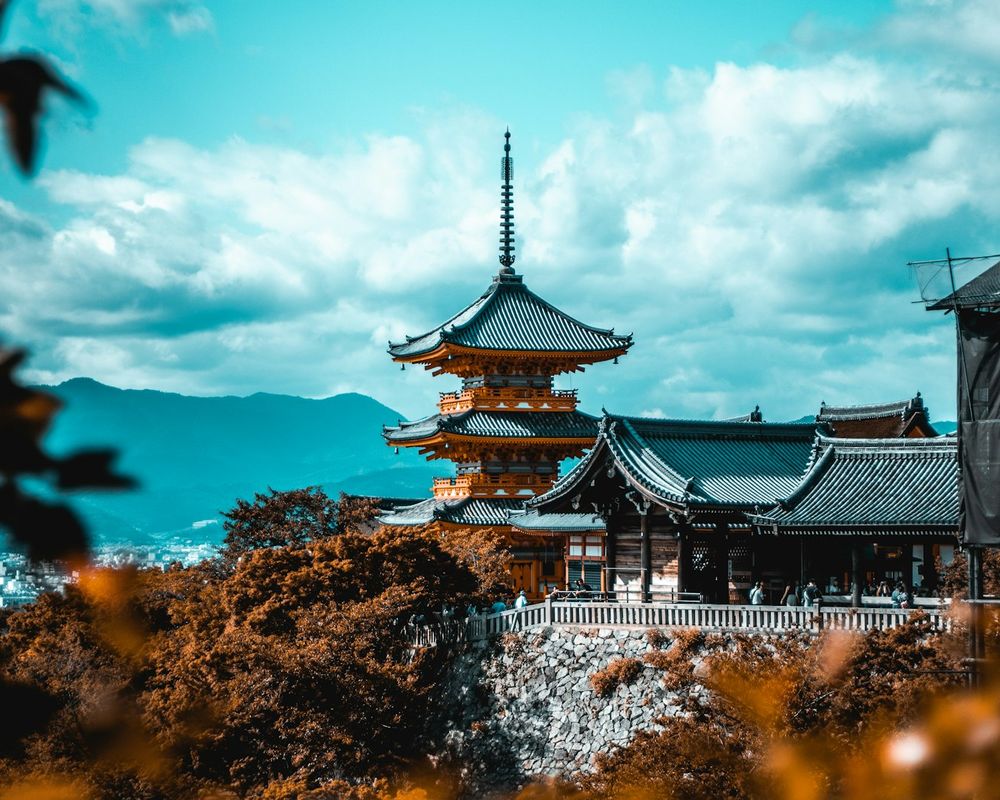 The three-storey pagoda of Kiyomizu-dera rising above autumn maples on the hills of Kyoto
